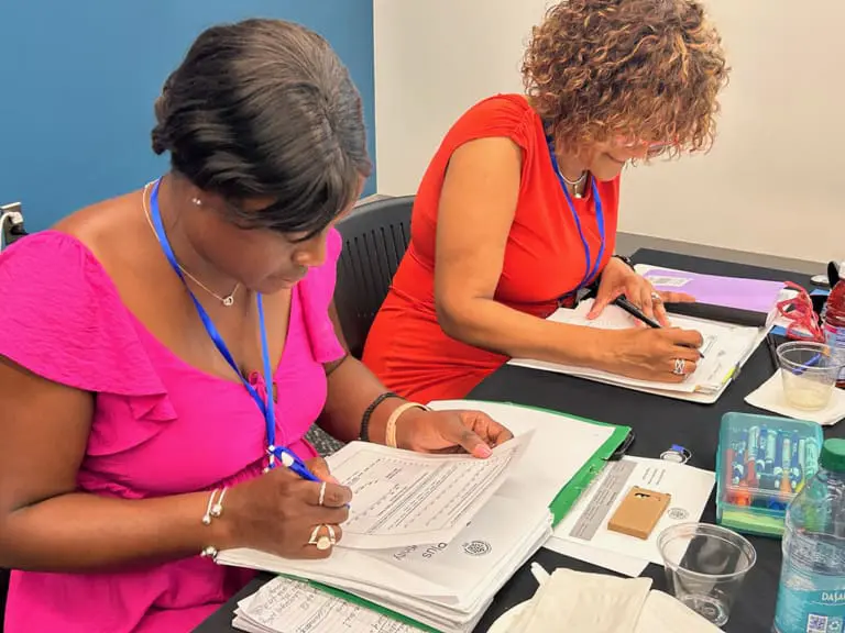 two women working on papers at a table