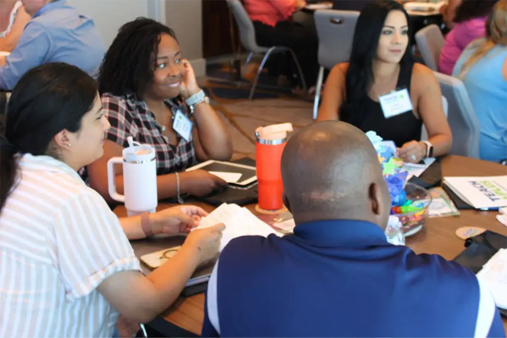 group of men and women discussing something around a table